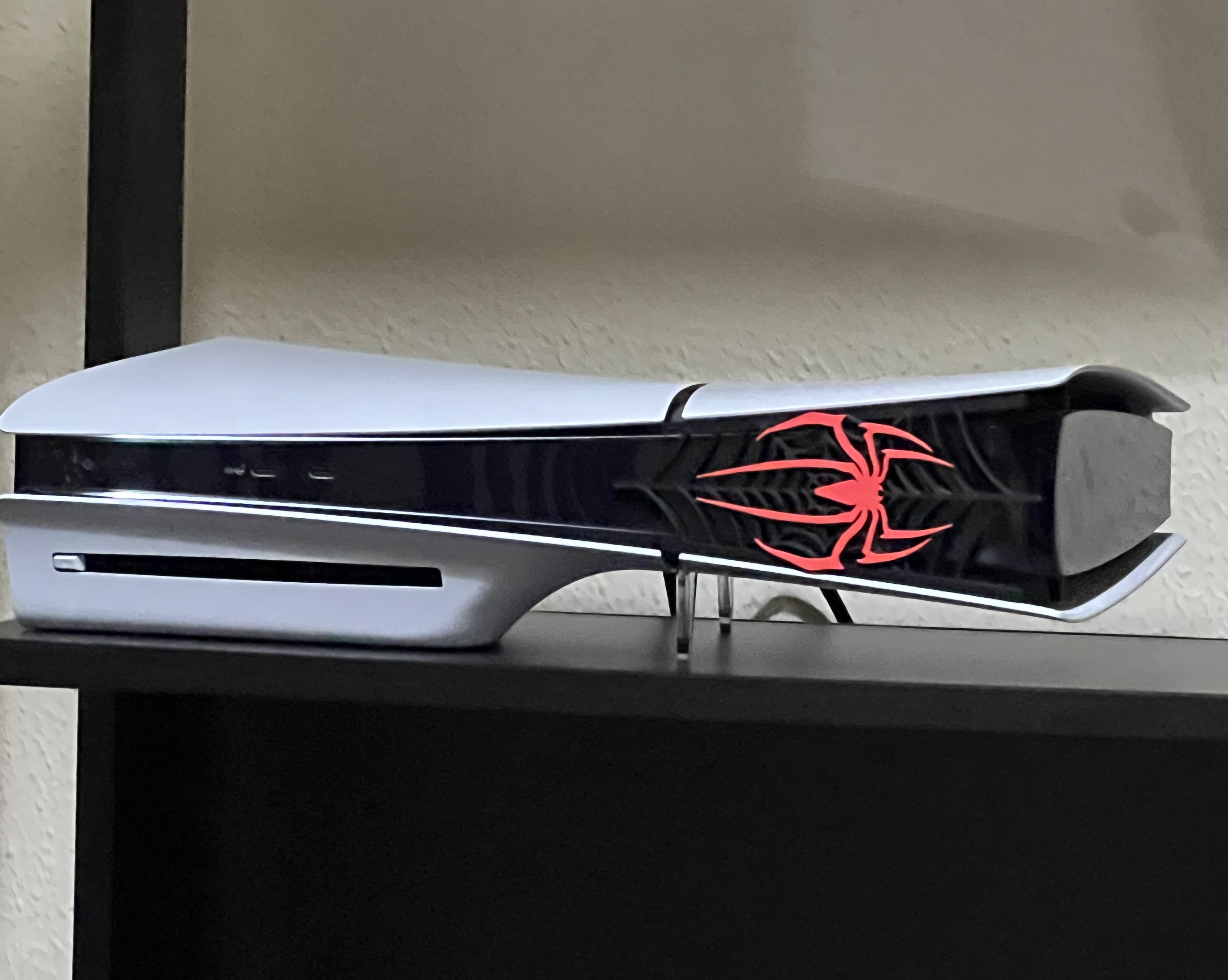 PlayStation 5 with custom black web-textured center panel and clear acrylic horizontal supports