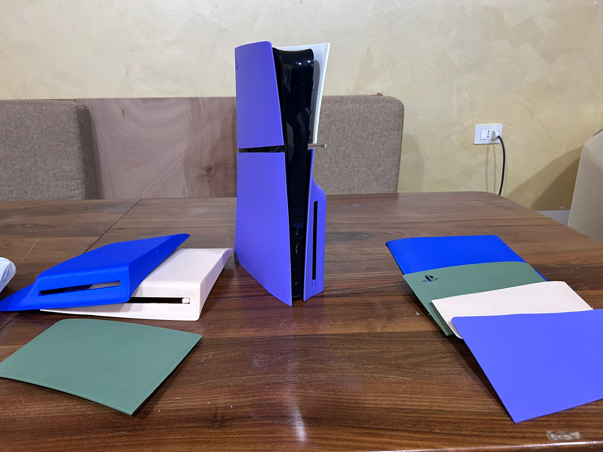 PlayStation 5 standing vertically with colorful interchangeable faceplates on and beside the console