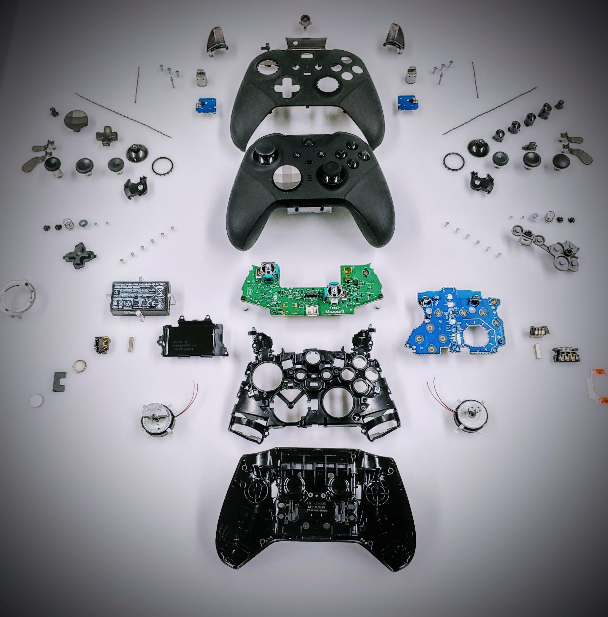 Exploded view of an Xbox Elite Series 2 controller with parts laid out on the bench